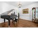 Classic living room with a grand piano, hardwood floors, and elegant decor at 4412 Thistlehill Ct, Raleigh, NC 27616