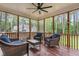 Inviting screened porch with stylish wicker furniture and a ceiling fan for outdoor relaxation at 4412 Thistlehill Ct, Raleigh, NC 27616