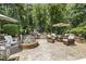 Inviting backyard patio featuring an outdoor kitchen, fire pit and comfortable seating area surrounded by lush landscaping at 5112 Highbury Grove Ln, Fuquay Varina, NC 27526