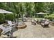 Inviting backyard patio featuring an outdoor kitchen, fire pit and comfortable seating area surrounded by lush landscaping at 5112 Highbury Grove Ln, Fuquay Varina, NC 27526