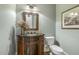 Stylish half-bathroom featuring decorative vanity, framed mirror, and elegant lighting fixtures at 5112 Highbury Grove Ln, Fuquay Varina, NC 27526