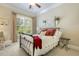 Cozy bedroom with iron bed frame, a bright window with a green outdoor view, and neutral tones at 5112 Highbury Grove Ln, Fuquay Varina, NC 27526