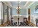 Elegant dining room with a chandelier, coffered ceiling, and large windows at 5112 Highbury Grove Ln, Fuquay Varina, NC 27526