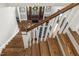 View from the stairs of the entryway with a wood door, wreath, and black and white rug at 5112 Highbury Grove Ln, Fuquay Varina, NC 27526