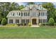 Stately two-story home with a brick facade, manicured lawn, black shutters, and charming dormer windows at 5112 Highbury Grove Ln, Fuquay Varina, NC 27526