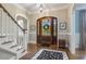 Elegant foyer with hardwood floors, staircase, detailed trim, and a charming arched doorway at 5112 Highbury Grove Ln, Fuquay Varina, NC 27526