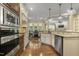 Spacious kitchen featuring stainless steel appliances, white cabinets, and hardwood floors at 5112 Highbury Grove Ln, Fuquay Varina, NC 27526