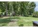 Beautiful backyard landscaping with mature trees, shrubs, and a well-manicured lawn at 5112 Highbury Grove Ln, Fuquay Varina, NC 27526