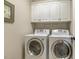 Efficient laundry room with a large washer and dryer and white cabinetry for storage, perfect for daily chores at 5112 Highbury Grove Ln, Fuquay Varina, NC 27526