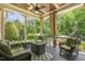 Inviting covered porch with stylish wicker furniture and a beautifully landscaped view at 5112 Highbury Grove Ln, Fuquay Varina, NC 27526