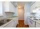 Efficient kitchen featuring white appliances and white cabinets, complete with a stainless steel sink at 514 Pine Ridge Pl, Raleigh, NC 27609