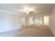 A bright living room showing neutral carpet, a ceiling fan, and a peek into the kitchen at 514 Pine Ridge Pl, Raleigh, NC 27609