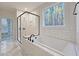 Modern bathroom featuring a soaking tub, glass-enclosed shower, and marble tile flooring at 5491 Silk Hope Gum Springs Rd, Siler City, NC 27344