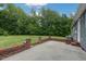 Spacious backyard featuring a brick patio, lush green lawn, mature trees providing ample shade and beauty at 578 Jeffries Cross Rd, Burlington, NC 27217