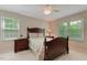 Comfortable bedroom featuring a queen bed, ceiling fan, and natural light from large windows overlooking the yard at 578 Jeffries Cross Rd, Burlington, NC 27217