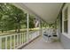 Inviting covered porch with white rocking chair overlooks landscaped front yard and American flag at 578 Jeffries Cross Rd, Burlington, NC 27217