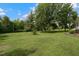 Expansive front yard featuring mature trees and lush green grass surrounding this lovely home at 578 Jeffries Cross Rd, Burlington, NC 27217