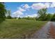 Rolling green acreage with a tree-lined private drive leading to a quaint single-story residence at 578 Jeffries Cross Rd, Burlington, NC 27217