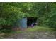 Weathered outbuilding surrounded by trees, offering a rustic, storage space in the woods at 578 Jeffries Cross Rd, Burlington, NC 27217