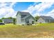 Backyard view of a two-story home with a patio, sliding glass doors, and green surroundings at 60 Waterwheel Dr, Selma, NC 27576