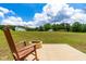 Relaxing backyard with a rocking chair and a stone fire pit on a sunny day at 60 Waterwheel Dr, Selma, NC 27576