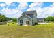Rear view of the home highlighting a spacious lawn, patio area, and exterior details at 60 Waterwheel Dr, Selma, NC 27576