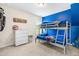 Fun bedroom features a bunk bed, bright blue accent wall, and ample space for activities at 60 Waterwheel Dr, Selma, NC 27576