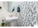 Stylish powder room featuring decorative floral wallpaper, a round mirror, and a pedestal sink at 60 Waterwheel Dr, Selma, NC 27576