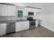 Bright kitchen with white cabinets, stainless steel appliances, and granite countertops at 600 Cecil St, Durham, NC 27707