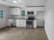 Bright kitchen with stainless steel appliances, white cabinets, granite countertops, and tile flooring at 600 Cecil St, Durham, NC 27707
