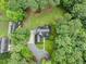 An aerial view displays the roof and driveway, enveloped by a lush canopy of trees at 635 Buckroe Dr, Sanford, NC 27330
