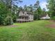 A home with a brick foundation sits on a well-manicured lawn surrounded by towering trees at 635 Buckroe Dr, Sanford, NC 27330