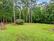 Expansive backyard with lush green grass, mature trees, and mulch beds at 635 Buckroe Dr, Sanford, NC 27330