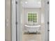 Bathroom with a white soaking tub next to window, tiled flooring, and bright light at 635 Buckroe Dr, Sanford, NC 27330