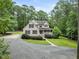 A gray house features a gabled roof, symmetrical window placement, and carefully curated shrubbery at 635 Buckroe Dr, Sanford, NC 27330