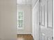 Hallway featuring hardwood floors, a window, and a large storage closet with white doors at 635 Buckroe Dr, Sanford, NC 27330