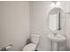 The half bathroom features a white toilet, pedestal sink, and oval mirror at 6618 Perry Creek Rd, Raleigh, NC 27616