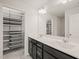 A bathroom featuring double sinks, a large mirror and an organized closet at 6618 Perry Creek Rd, Raleigh, NC 27616