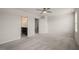 Carpeted bedroom with ceiling fan and view into the en suite bathroom and closet at 6618 Perry Creek Rd, Raleigh, NC 27616