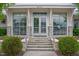 Clubhouse entry featuring symmetrical architecture with stone columns, stairs, and double glass doors at 6618 Perry Creek Rd, Raleigh, NC 27616