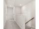 Upstairs hallway with neutral carpet, white walls, and a wooden handrail at 6618 Perry Creek Rd, Raleigh, NC 27616