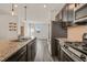 Open concept kitchen features a granite-topped island, stainless steel appliances, and modern fixtures at 6618 Perry Creek Rd, Raleigh, NC 27616