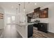 Bright kitchen featuring a large granite island, stainless steel appliances, pendant lighting, and dark wood cabinets at 6618 Perry Creek Rd, Raleigh, NC 27616
