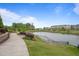 Pond view with landscaped walking path, surrounding greenery, and residential buildings in the background at 6618 Perry Creek Rd, Raleigh, NC 27616