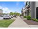 Street view showcasing storefronts with modern architecture, sidewalk, and parked cars under a bright sky at 6618 Perry Creek Rd, Raleigh, NC 27616