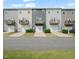 Row of gray townhomes, each with a garage, small balcony, and well-maintained lawn at 6618 Perry Creek Rd, Raleigh, NC 27616