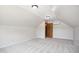 Finished attic space with carpet and a door to storage at 8509 Ashwood Dr, Raleigh, NC 27603