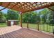 Back deck area with wooden flooring, shed, and green landscape with a black iron fence at 8509 Ashwood Dr, Raleigh, NC 27603