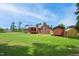 Exterior view of the backyard with the house, wooden deck, shed, and green grass at 8509 Ashwood Dr, Raleigh, NC 27603