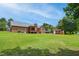 Expansive backyard featuring a brick home, wooden deck with pergola, shed, and recreational vehicle parking on a lush lawn at 8509 Ashwood Dr, Raleigh, NC 27603